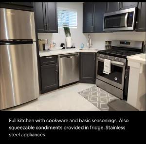a kitchen with black cabinets and stainless steel appliances at Downtown and Inner Harbor Apartment in Baltimore