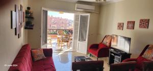 a living room with a couch and chairs and a television at Lazorde Bay Apartment in El Alamein
