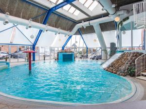 a large indoor swimming pool with blue water at 6 person holiday home on a holiday park in Hejls in Hejls +33 photos