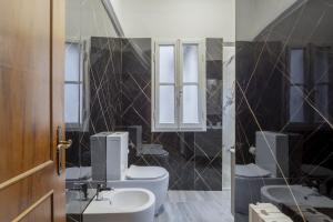 a bathroom with two toilets and a sink and a mirror at Delux Via Faenza in Florence +6 photos