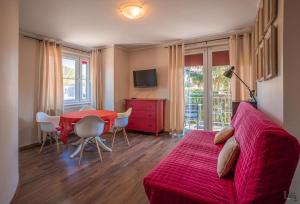 a living room with a red couch and a table at Willa Anna in Jastarnia