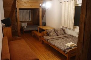 a bedroom with a bed and a couch in a room at Cottage CHILL ZONE in Yaremche