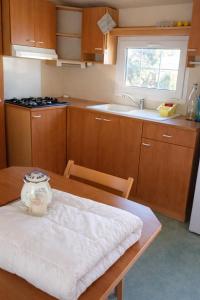 a kitchen with a wooden table with a vase on it at Mobil-home tout équipé Le Castellet les pins doux 2 in Le Castellet