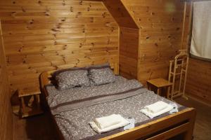 a bedroom with a bed in a wooden wall at Cottage CHILL ZONE in Yaremche
