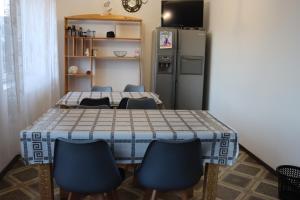 a kitchen with a table and chairs and a refrigerator at Cottage CHILL ZONE in Yaremche