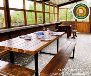 a large wooden table in a room with windows at Glamping Bugambilia in Subía