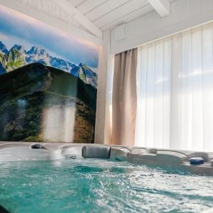 a bath tub in a room with a painting on the wall at Vila Merak in Gusinje