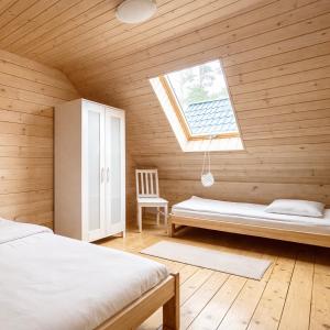 a room with two beds and a window at Morska Fala Domki in Pobierowo