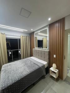 a bedroom with a large bed and a mirror at Recanto do Sol in Governador Celso Ramos