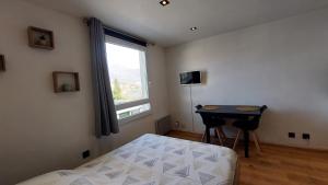 a bedroom with a bed and a desk and a window at Studio in Chambéry
