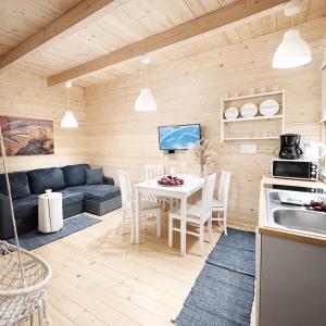 a kitchen and living room with a couch and a table at Morska Fala Domki in Pobierowo