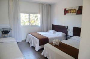 ein Hotelzimmer mit zwei Betten und einem Fenster in der Unterkunft Hotel Oaky in Posadas