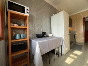 a kitchen with a table and a white refrigerator at CasaMaria in Vila do Conde