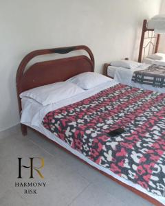 a bed with a red and black blanket on it at Harmony Risk in Albán