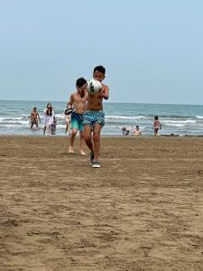 two boys playing with a soccer ball on the beach at Sea Breeze, Polo Residence, Baku, MR in Nardaran