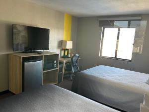 a hotel room with two beds and a flat screen tv at Super 8 by Wyndham Fort Scott in Fort Scott