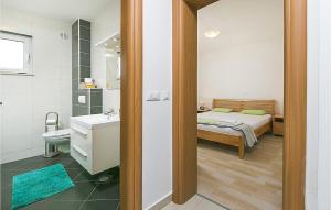 a bedroom with a bed and a bathroom with a sink at Beautiful Apartment In Brela With Wifi in Brela