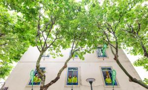 a group of people in the windows of a building at Help Yourself Hostels - Parede in Parede