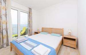 a bedroom with a bed and a large window at Beautiful Apartment In Brela With Wifi in Brela