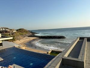 a swimming pool next to a beach with the ocean at Studio B Luxury - Waterfront in Dakar