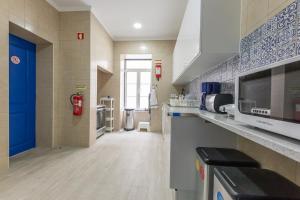a kitchen with a blue door and a counter top at Help Yourself Hostels - Parede in Parede