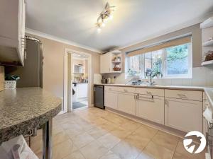 a kitchen with white cabinets and a large window at 6 Bed Longstay & Shortstay property with Wifi & parking sleeps 14 in Chatham