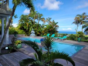 a villa with a swimming pool and the ocean at Habitation Tara in Capesterre-Belle-Eau