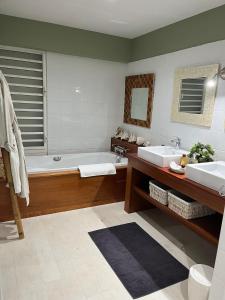 a bathroom with two sinks and a bath tub at Habitation Tara in Capesterre-Belle-Eau +17 photos