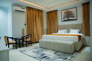 a bedroom with a bed and a table in it at Nirvana City Hotel in Benin City +72 photos