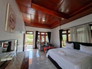 a bedroom with a large bed and a fireplace at Juma cottages in Tuktuk Siadong