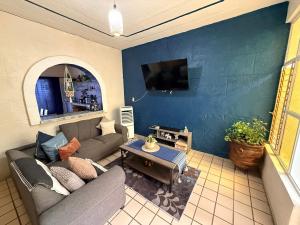 a living room with a couch and a tv at Casa Valentía in Tequila