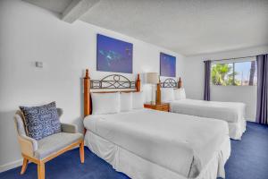 a hotel room with two beds and a chair at Oceanside Marina Suites - A Waterfront Hotel in Oceanside +49 photos