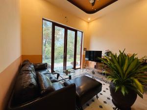 a living room with a leather couch and a large window at Rustic Homeaway - Stay with the local in Phong Ðiền