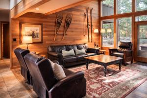 a living room with a leather couch and a table at Rock Ridge 009 in Black Butte Ranch
