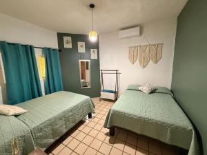 two beds in a room with green walls at Casa Valentía in Tequila +35 photos