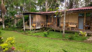 a house with a porch and a yard at Retazos Eco Hotel in Iquitos