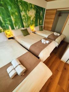a group of three beds in a room at Lucky民泊 in Osaka