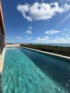 a swimming pool with a view of the ocean at Beach Studio Playa del Carmen MX in Playa del Carmen