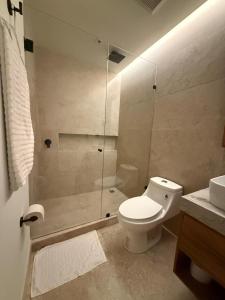 a bathroom with a toilet and a glass shower at Beach Studio Playa del Carmen MX in Playa del Carmen +3 photos
