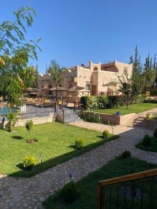 a view of a park with a building in the background at Villa AMMA, piscine chauffée in Essaouira