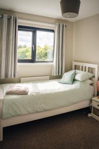 a bedroom with a large bed with a window at Moat View Donaghadee in Donaghadee