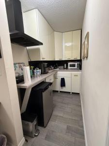 a small kitchen with white cabinets and a counter at Suit with Kitchen & Bath in Cocoa