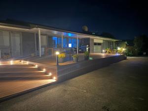 a house with lights on a deck at night at B&B at whitbourne in Otorohanga