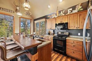a kitchen with wooden cabinets and a black stove top oven at The Great Escape in Lead +14 photos