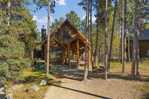 a log cabin in the woods with trees at The Great Escape in Lead