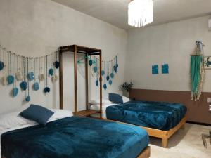 two beds in a room with blue sheets at Bacalar Inn Hotel & Glamping Bacalar in Bacalar
