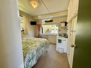 a small bedroom with a bed and a window at Ridgehaven Accommodation in Opotiki
