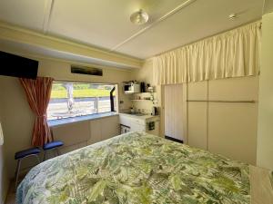 a small bedroom with a bed and a window at Ridgehaven Accommodation in Opotiki