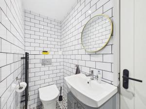 a white bathroom with a sink and a mirror at The Costwold Haven in Shurdington