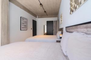 two beds in a bedroom with white walls at Zielo Rentals Palma ,Private balcony, Rooftop Walk to Zocalo in Mexico City